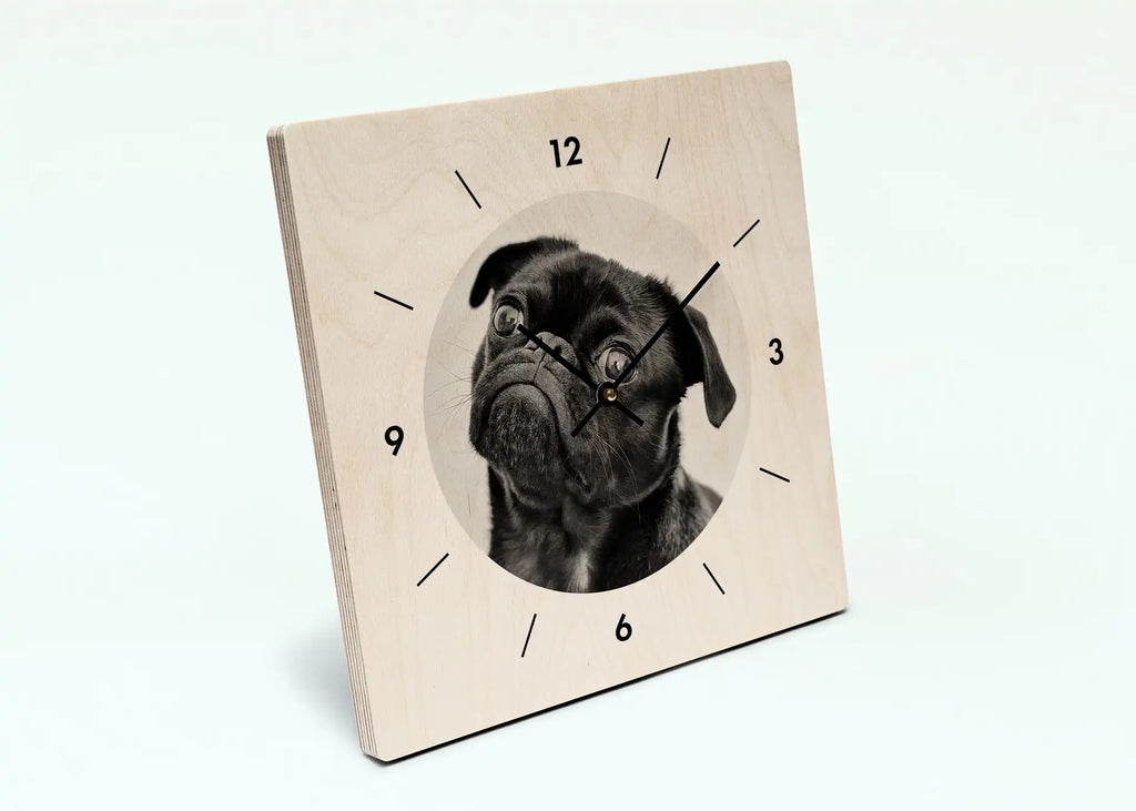 Square wall clock featuring a black pug’s face as the centerpiece.