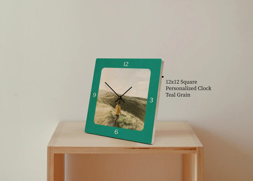 Teal-framed square clock with a beach scene photo display.